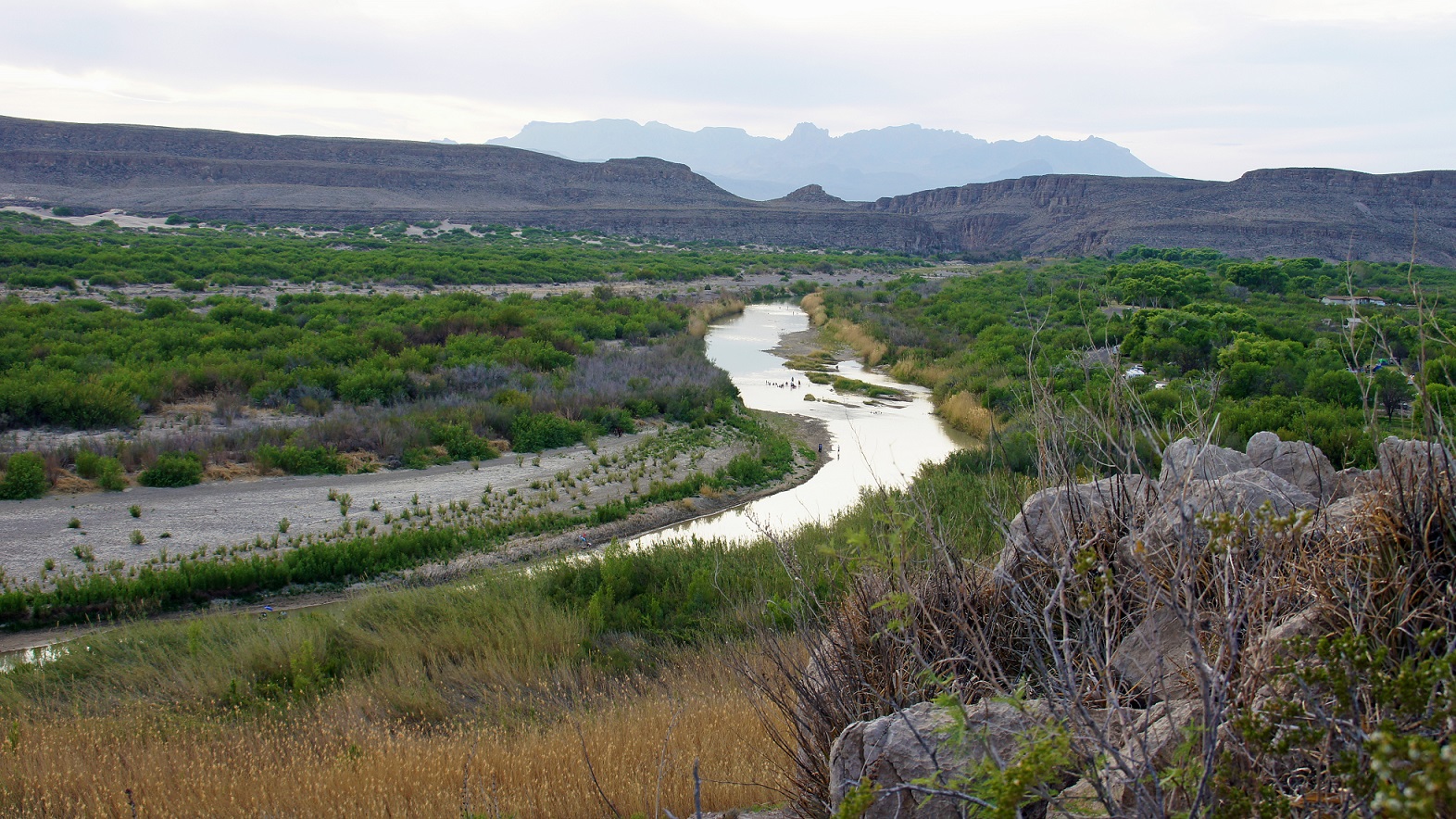 Scenic desert landscape of Big Bend National Park showing river with mountains in the background.