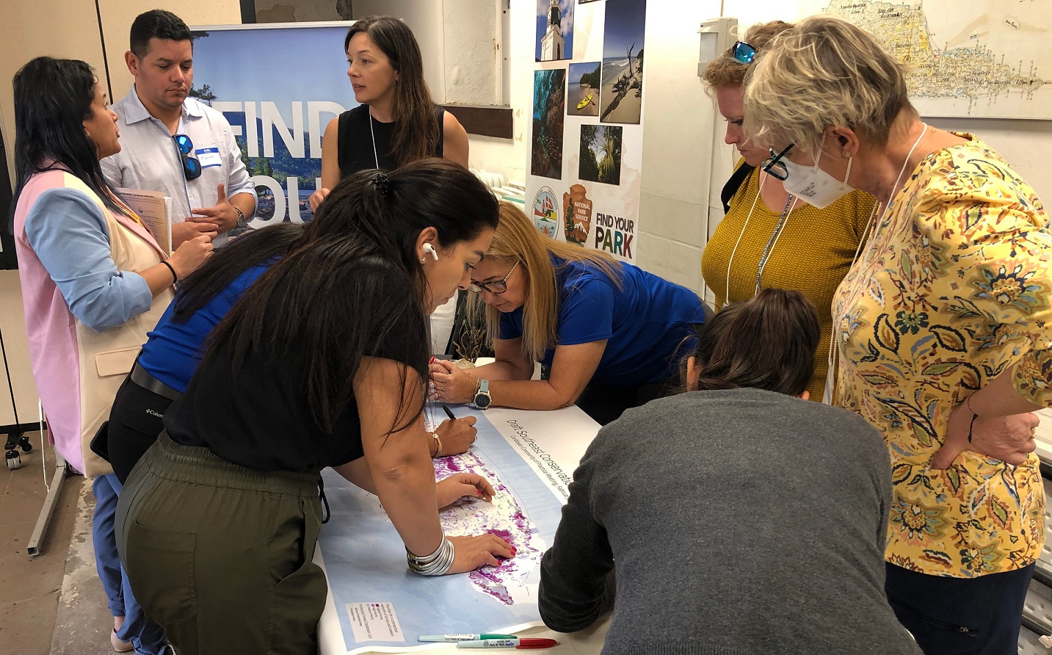 A group of conservation professionals investigating a map.