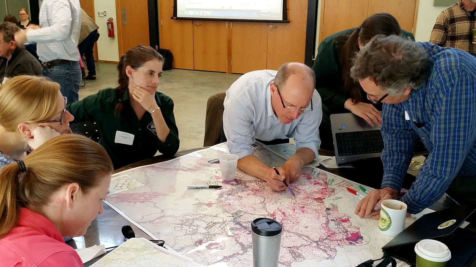 A group of conservation professionals investigating a map.